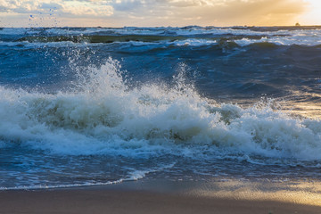 sunset in the cloudy sky over the stormy sea