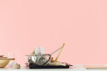 various messy cooking utensils on table isolated on pink