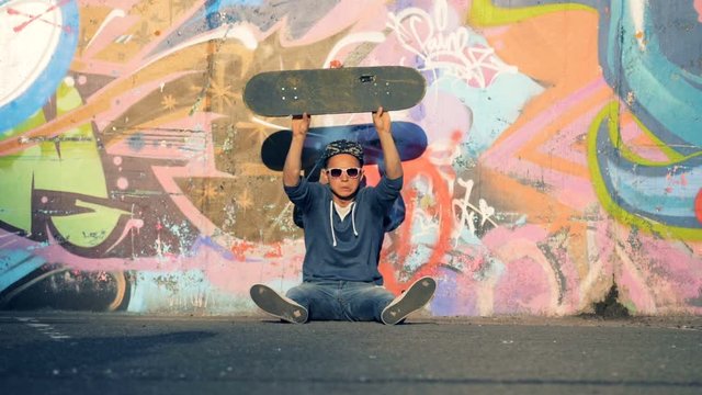 A person throws skateboard angrily, slow motion.