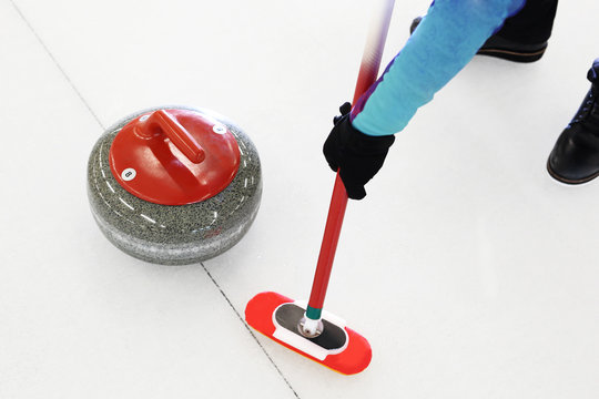 Gra w curling. Zawodnik gra w curling na lodowisku
