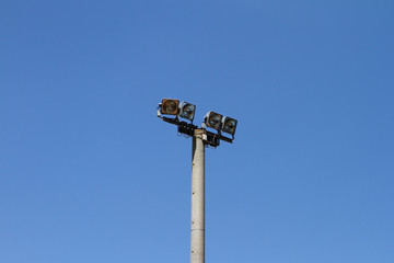 Big grey concrete lighting pole on a blue sky background, objects photo