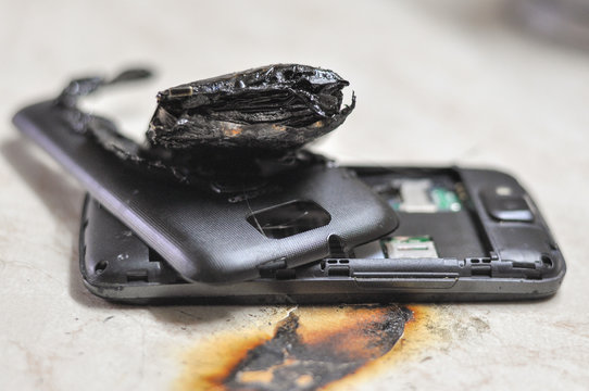 Mobile phone battery explodes and burns due to overheat. Danger, exploded mobile phone battery