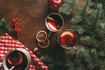 top view of glass cups with homemade hot spiced wine on wooden background with viburnum berries and...