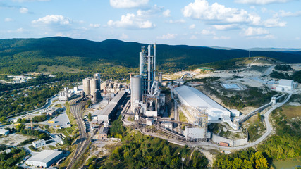 Aerial view of cement manufacturing plant. Concept of buildings at the factory, steel pipes, giants. - obrazy, fototapety, plakaty