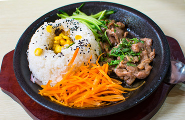 A set of meal with rice, beef, cucumber and carrot served on the