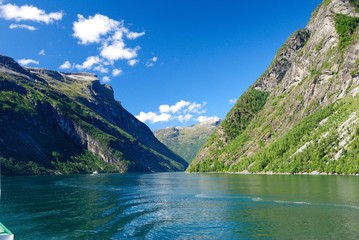 Naklejka na ściany i meble View of nearby mountains and waterfalls from the Geirangerfjord in Norway