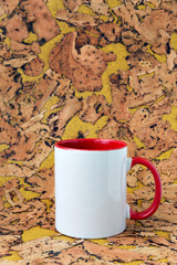 Obraz premium White mug with a red handle on a background of a textured cork.