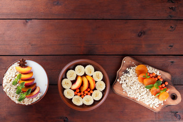 Oatmeal with fruits and green mint. Oat flakes with milk and dried apricots on wooden background. Healthy food for vegans. Dry oats with peaches, anise and berries of mountain ash. Copy space