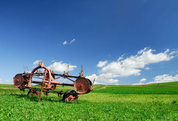 Agricultural machine on a green pasture