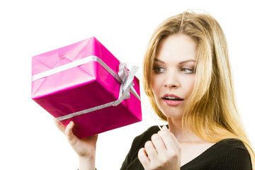 Curious woman holding gift box