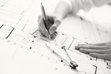 Black and white photo of architect working on house plan