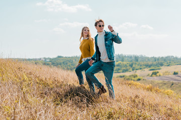 attractive couple walking on rural meadow