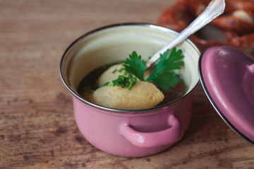 heiße bayerische Grieß nockerl suppe Brühe für den Winter in einem kleinen Top mit Breze auf einer Berghütte Wirtshaus gegen Erkältung
