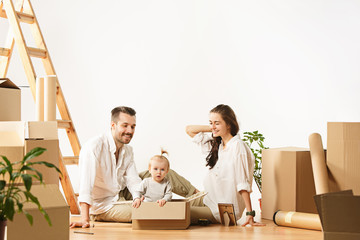 Couple moving to a new home. Happy married people with newborn child buy a new apartment to start...
