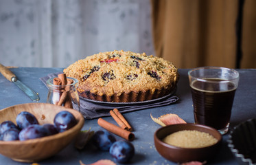 Homemade rustic plum cake on dark concrete background. Sweet fruits pie.