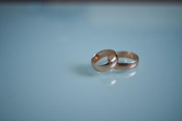 wedding rings lie on a blue transparent background isolated. wedding rings concept symbol