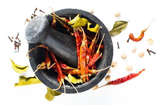 Food concept Exotic Thai dried spices chilies in mortar, Kaffir lime, cloves, thai cardamom white pod and coriander seeds on white background