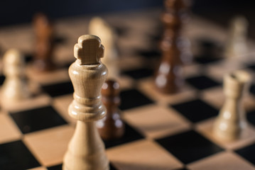 Chess on chessboard close up with focus on white king