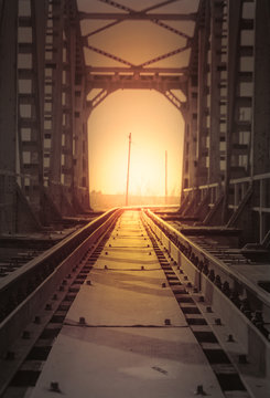 Fototapeta Old railway iron bridge and sunset in the background