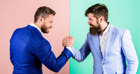 Business partners competitors office colleagues tense faces ready to compete in arm wrestling....