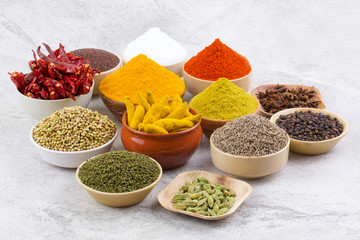 Indian Spices Collection Also Called Chili Powder, Turmeric Powder, Coriander, Fenugreek, Cumin, Mustard Seed, Salt, Black Pepper, Cardamom, Cloves, Turmeric Stick, Dry Chili on Vintage Background