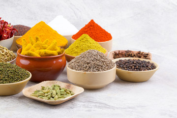 Indian Spices Collection Also Called Chili Powder, Turmeric Powder, Coriander, Fenugreek, Cumin, Mustard Seed, Salt, Black Pepper, Cardamom, Cloves, Turmeric Stick, Dry Chili on Vintage Background