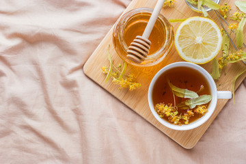 Tea with Linden, honey and Lemon. The tray on the bed, the Concept of the treatment of colds.