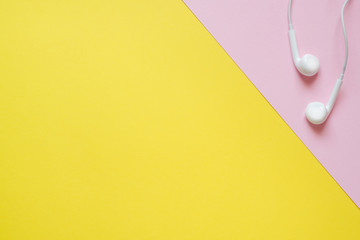 Headphones from the player on a pink and yellow table with a copy of the space. Education concept,...