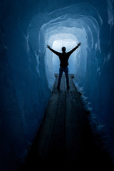 Silhouette of a man walking through a ice tunnel