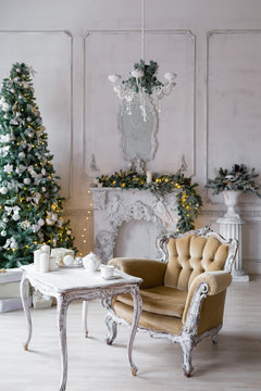 Christmas morning . classic apartments with a white fireplace, decorated fir tree, sofa, large windows and chandelier.
