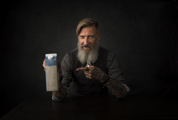Portrait eines bärtigen Mannes im Studio mit einem Milchtüte.