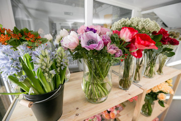Fototapeta na wymiar Fresh spring flowers in refrigerator for flowers in flower shop. Bouquets on shelf, florist business.