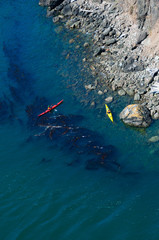 Bright kayakers and a stone