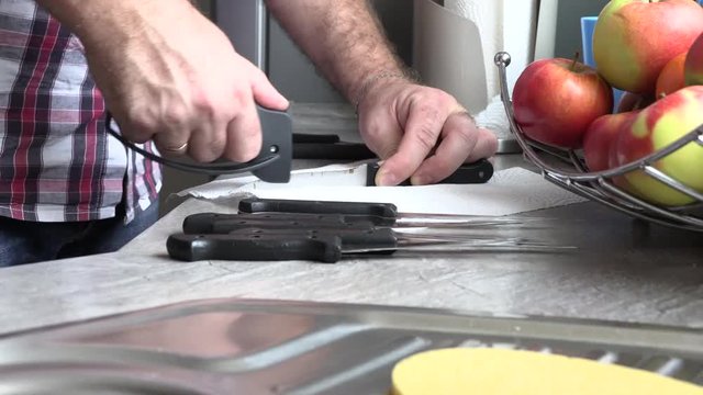 The man is sharpening a kitchen knife