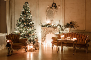 Fototapeta na wymiar Christmas tree, garlands, candles,lanterns, gifts in the evening. classical interior of a white room with a decorated fireplace, sofa,