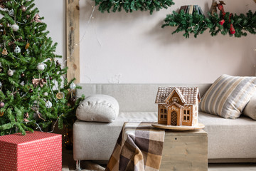 Xmas in morning living room. Sofa bed In christmas Interior. celebrate the new year and holidays. Christmas tree and gingerbread house