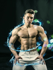 Fototapeta na wymiar Young handsome man with muscular shirtless torso in white denim and glowing blue spiral line looking at camera