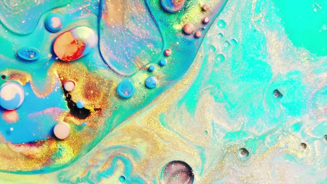 Colorful paints mix in beautiful patterns. Oil ink of different colors slowly spread on the surface and mix one into another creating new colors and amazing textures and design.