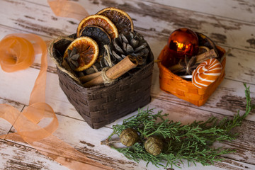 Christmas decorations. orange and brown decorations with cinnamon sticks, anise stars, dry oranges, wooden decorations, firtree branches on the white wooden table