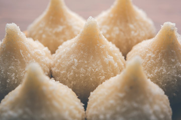 Sweet Modak made using coconut, khoya and sugar. Popular Maharashtrian recipe offered to lord Ganesha in Ganesh Festival. Served in a plate. Selective focus