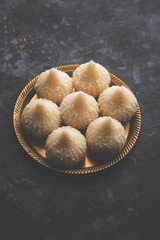 Sweet Modak made using coconut, khoya and sugar. Popular Maharashtrian recipe offered to lord Ganesha in Ganesh Festival. Served in a plate. Selective focus