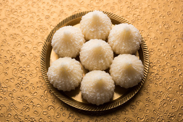 Sweet Modak made using coconut, khoya and sugar. Popular Maharashtrian recipe offered to lord Ganesha in Ganesh Festival. Served in a plate. Selective focus