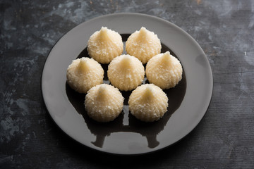 Sweet Modak made using coconut, khoya and sugar. Popular Maharashtrian recipe offered to lord Ganesha in Ganesh Festival. Served in a plate. Selective focus