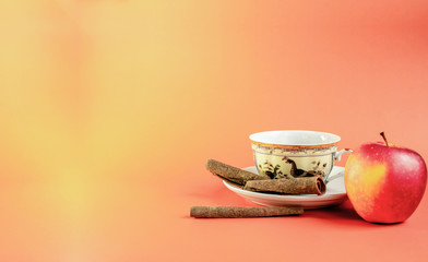 Porcelain cup of afternoon tea with apple and cinnamon - obrazy, fototapety, plakaty