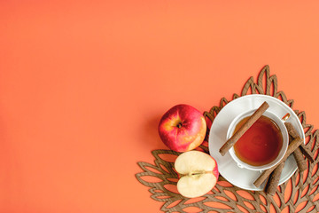 Orange background with apple and cinnamon flavour hot tea