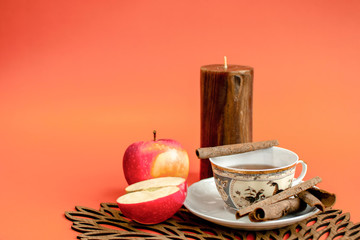 Warm home atmosphere with a candle, and hot, apple and cinnamon flavour 