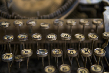 Close up view on an old dirty broken antique typewriter machine keys with Cyrillic symbols letters.