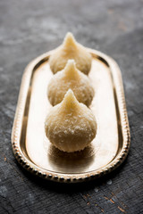 Sweet Modak made using coconut, khoya and sugar. Popular Maharashtrian recipe offered to lord Ganesha in Ganesh Festival. Served in a plate. Selective focus