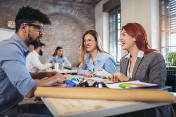  Group of young business people in smart casual wear working together in creative office
