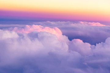 Fototapeta na wymiar Beautiful sunset sky above clouds with nice dramatic light. View from airplane window